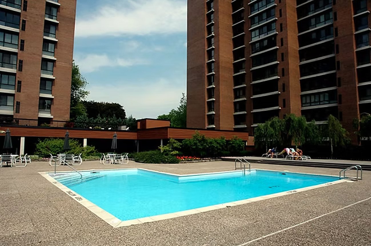 The outdoor pool surrounded by a wide sun deck, with the towers behind